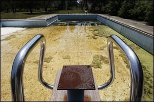 Stagnant water has collected at the Highland Park Pool in South Toledo, deemed beyond repair by Toledo officials. Some area residents remember going to the pool during childhood and are frustrated their own children cannot enjoy the same fun they did.