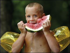 Kasey Lairsey, 6, enjoys watermelon after a swim in the Flint River while out with family and friends in Mitchell County, Georgia. Temperatures there hit the high 90s Sunday. The eastern part of the nation is receiving a break from 100-degree days.