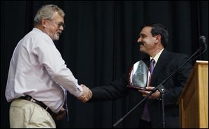 the bladeRetiring Superintendent Russell Griggs, left, received an award in 2010 from Fayette board President David Brinegar for his work with the school's wind turbines.
