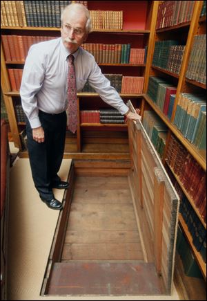 Thomas Culbertson shows a trap door concealing a foot-deep hiding place in the library, discovered when carpet was pulled up.