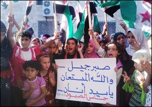 Syrian children chant slogans and hold an Arabic poster reading 