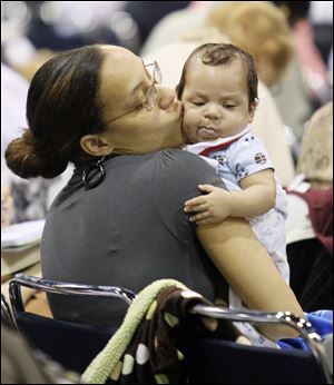 Roslyn Frank of Grosse Pointe, Mich., kisses her 2-month-old son, Jacob Peterson, while listening to a speaker during the event.