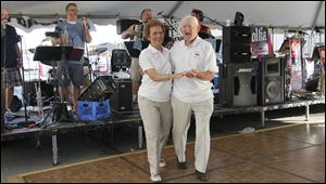 Toledoans Carol Zomkowski and Daniel Wozniak show off their polka dance steps. They were dancing to the band Badinov Friday in the dance tent near Czelusta Park on Lagrange Street.