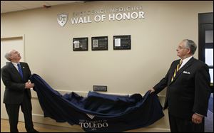 Dr. Jeffrey Gold, left, chancellor and executive vice president for biosciences and health affairs  and dean of the University of Toledo's Health Sciences Campus, the former Medical College of Ohio, helps Joseph H. Zerbey IV, president and general manager of The Blade, unveil the plaques.