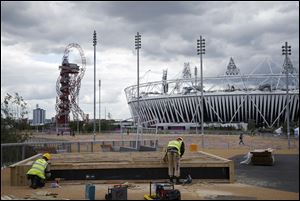 Construction crews work outside the Olympic Stadium as preparations continue for the 2012 Summer Olympics, Sunday.