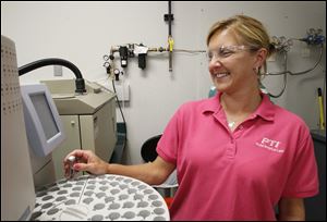 Lori Drown, a lab technician at Plastic Technologies Inc., analyzes a plastic sample on a gas chromatograph. Her employer said she and other workers most likely won't be affected by the Affordable Care Act because the firm offers a premium health plan to workers.