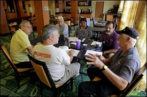 Terry White, far right, leads a discussion during a business development meeting of former space workers, clockwise from center, John Hoog, Raymond Steele, Kenneth Mark Higginson Jr., Kay Sunderland and Kevin Harrington, in Titusville, Fla. 