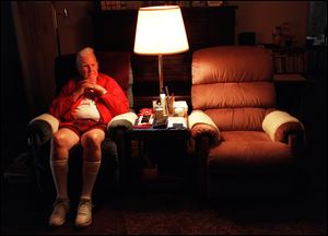Jack Farrington sits in his living room next to his wife's chair. He has been alone for 20 months since his wife died. Widowers find little support after the death of their spouse unlike widows who have support groups and family who will talk openly about it while the men are expected to remain strong and silent.