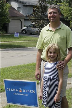 Daniel Greenberg pauses with his daughter Nina, 7, at the sign that a Sylvania zoning official ordered him to remove. Mr. Greenberg has filed a lawsuit in federal court in Toledo saying the ordinance violates his First Amendment free speech rights. The sign is to remain until a hearing Monday.
