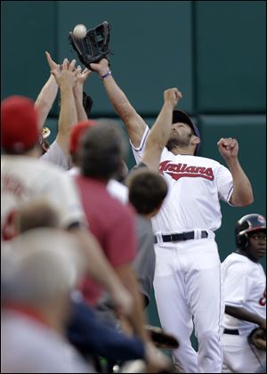 Cleveland Indians left fielder Johnny Damon leaps into the stands to catch a foul ball by Baltimore Orioles' Nick Markakis in the third inning of a baseball game Friday.