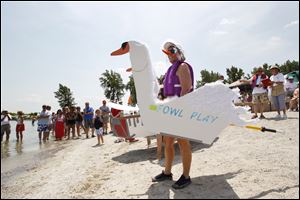 The festivities for North Cape Yacht Club’s 50th anniversary included a cardboard boat race. Sheila Brown prepares to race her boat Fowl Play in hopes of winning a coveted trophy made of Cardboard as well.