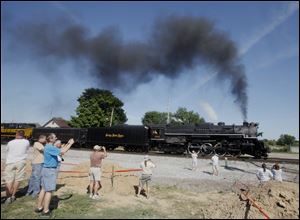 The Nickel Plate Road 765 steam engine passing on-lookers in Bellevue, Ohio.