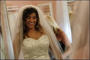 Katelyn Kellermeier tries on a cathedral veil at Encore Bridal in Bowling Green.