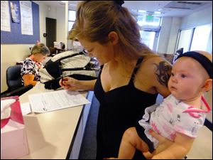 Laura Fritz, 27, left, with her daughter Adalade Goudeseune fills out a form at the Jefferson Action Center, an assistance center in the Denver suburb of Lakewood. Both Fritz grew up in the Denver suburbs a solidly middle class family, but she and her boyfriend, who has struggled to find work, and are now relying on government assistance to cover food and $650 rent for their family. The ranks of America's poor are on track to climb to levels unseen in nearly half a century, erasing gains from the war on poverty in the 1960s amid a weak economy and fraying government safety net. Census figures for 2011 will be released this fall in the critical weeks ahead of the November elections.
