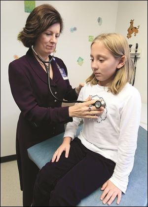 Dr. Elaine Urbina examines Joscelyn Benninghoff, 10, at Children's Hospital in Cincinnati. Joscelyn takes medication to control her cholesterol.