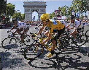 Bradley Wiggins of Britain, wearing the overall leader's yellow jersey, passes the Arc de Triomphe during the 20th stage of the Tour de France on Sunday in Paris. Wiggins became the first Englishman to win the event.