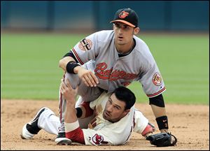 Baltimore second baseman Ryan Flaherty falls on Cleveland's Jason Kipnis after trying to turn a double play in the sixth inning.