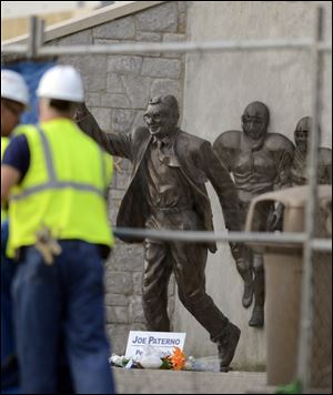 Scaffolding to be covered by tarps frames the statue. Penn State's president said leaving the sculpture in place would be a recurring wound to abuse victims.