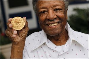 Carmen Williamson, 82, poses with his Olympic gold medal which he received for being named the 'top official' during the '84 Games.