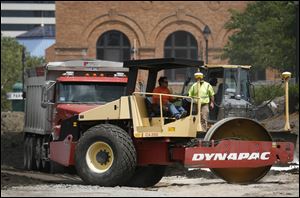 Equipment rolls through the area near the former steam plant, which is proposed to be apartments, a health clinic, and a YMCA branch.
