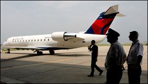 Comair employees admire the new logo on a plane at Cincinnati-Northern Kentucky International Airport in 2007. Delta Air Lines said Friday it would shut down the regional carrier in September.