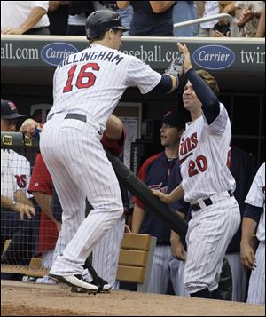 Minnesota Twins' Josh Willingham (16) is congratulated by teammate Brian Dozier (20) after hitting a two-run home run during the fourth inning in a baseball game against the Cleveland Indian.