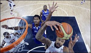 USA's Tyson Chandler, right, grabs a rebound in front of France's Mickael Gelabale, left, during the first half of a preliminary men's basketball game at the 2012 Summer Olympics, Sunday.