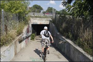 A bicyclist races through the Interstate 75 underground pedestrian path on South Ave. in Toledo, Ohio.