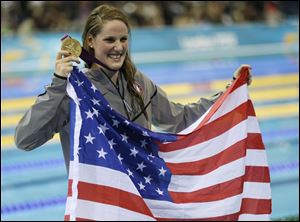 Missy Franklin, a 17-year-old phenom, clutches the American flag and her first gold medal after winning the 100-meter backstroke.