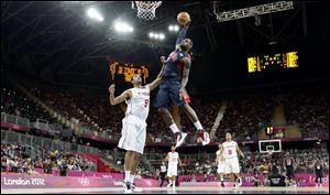 USA's Lebron James, right, dunks over Tunisia's Mohamed Hadidane, left, during the first half of a preliminary men's basketball game at the 2012 Summer Olympics, Tuesday.