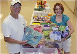 Holland Free Methodist Church administrator Mike Yunker and project coordinator Christy Winckles organize the back-to-school supplies the church will make available at no charge Aug. 8 to children in need.