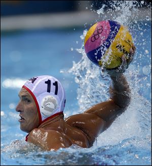 American Jesse Smith holds the ball during a men's preliminary water polo match against Romania on Tuesday in London. The United States rallied from two early deficits to win 10-8 and remain unbeaten. The win puts the U.S. even with gold medal-favorite Serbia atop Group B with four points.