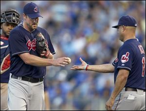 Cleveland Indians starting pitcher Derek Lowe, left, hands the ball to manager Manny Acta during the third inning of a baseball game against the Kansas City Royals at Kauffman Stadium in Kansas City, Mo., Tuesday.