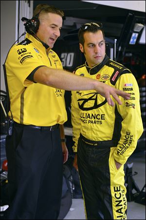 Crew chief Chad Walter, left, and Sam Hornish Jr., talk during practice for the NASCAR Nationwide Series auto race at Indianapolis Motor Speedway.