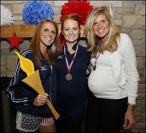 Sisters, from left, Emily Florian, Erica McVicker, and Sarah Iceman at the Summer Olympics kickoff party at Preston Gardens Apartments Clubhouse in Perrysburg.