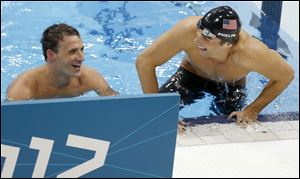 Michael Phelps, right, and teammate Ryan Lochte smile as they leave the pool after Phelps' gold medal win and Lochte's silver medal finish in the men's 200-meter individual medley.