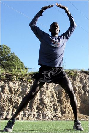 Guor Marial, 28, does jumping jacks on a soccer field in Flagstaff, Ariz. The Sudanese refugee learned just weeks ago that he could compete in the men's marathon at the Olympics as an independent athlete.