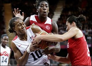 Tamika Catchings (10) of the United States and Turkey's Tugce Canitez, right, fight for the ball as Turkey's Kuanitra Holingsvorth looks on.