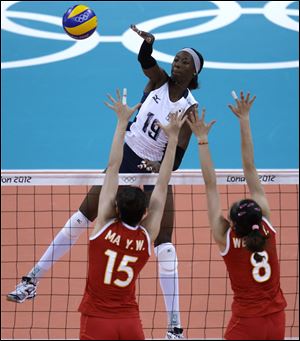 Destinee Hooker (19) spikes over China's Ma Yunwen (15) and Wei Qiuyue during a preliminary match Wednesday as the No. 1- ranked U.S. won all three sets.