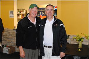 Mark Gooremont and former Lourdes president Robert Helmer try to keep dry in the clubhouse at Bedford Hills Golf Club for the Lourdes University Hit the Links golf outing.