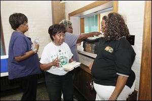 Mildred Clark of Springfield Township, left, who is raising her teenaged great-granddaughter, talks with Jamie Richardson, programming director for the Kinship Navigator Program at a meeting of kinship caregivers.