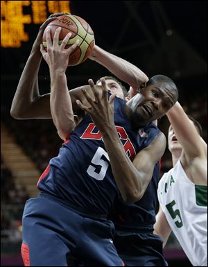 USA's Kevin Durant, left, and Lithuania's Mantas Kalnietis, right,  scramble for a rebound during a preliminary men's basketball game at the 2012 Summer Olympics.