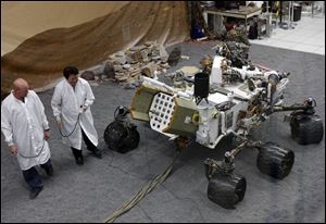 Engineers work on a model of the Mars rover Curiosity at the Spacecraft Assembly Facility at NASA's Jet Propulsion Laboratory in Pasadena, Calif.
