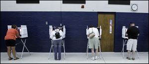 Voters cast their ballot at the Monroe Family YMCA in Monroe, Mich.