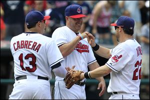 Cleveland Indians manager Manny Acta, center, smiles as he congratulates Asdrubal Cabrera, left, and Jason Kipnis after the Indians defeated the Minnesota Twins 6-2.