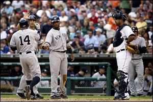 New York Yankees' Curtis Granderson (14) is congratulated by Eric Chavez, left, and Robinson Cano, right following Granderson's three-run home run against the Detroit Tigers during the third inning Wednesday.