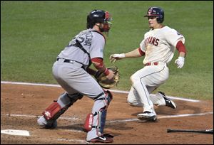 Cleveland Indians' Brent Lillibridge, right, scores around Boston Red Sox catcher Jarrod Saltalamacchia on a suicide squeeze bunt in the seventh inning of a baseball game on Saturday.