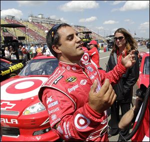 Juan Pablo Montoya talks with a crew member after winning the pole during qualifying for the NASCAR Sprint Cup Series race at Watkins Glen International in Watkins Glen, N.Y., Saturday.