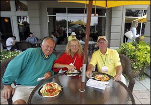 Bob Hodak, left, Mary Thomas, center, and Ed Grabowski, right, enjoy the patio of the clubhouse during the Jamie Farr at Highland Meadows Golf Club.