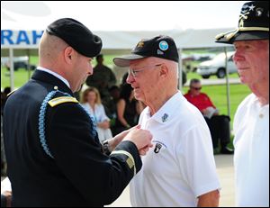 U.S. Army, Col. Val Keaveny Jr., left, commander of the 4th Brigade Combat Team, 101st Airborne Division, pins Herbert Suerth Jr., a World War II veteran of Easy Company, 506th Parachute Infantry Regiment, as a Distinguished Member of the Regiment during a ceremony at Fort Campbell, Ky., on July 20.